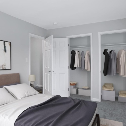 a bedroom with a bed painting on the wall and closets